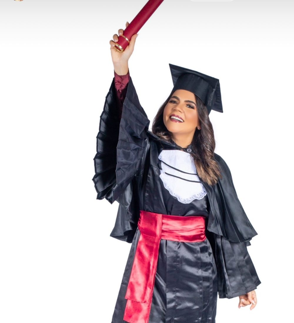 Moama de beca erguendo o diploma